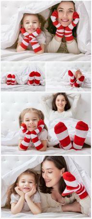 DesignOptimal Cheerful little daughter and mom on bed stock photo